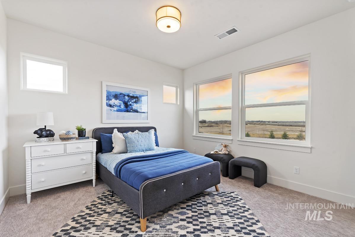 Bedroom featuring multiple windows and light carpet