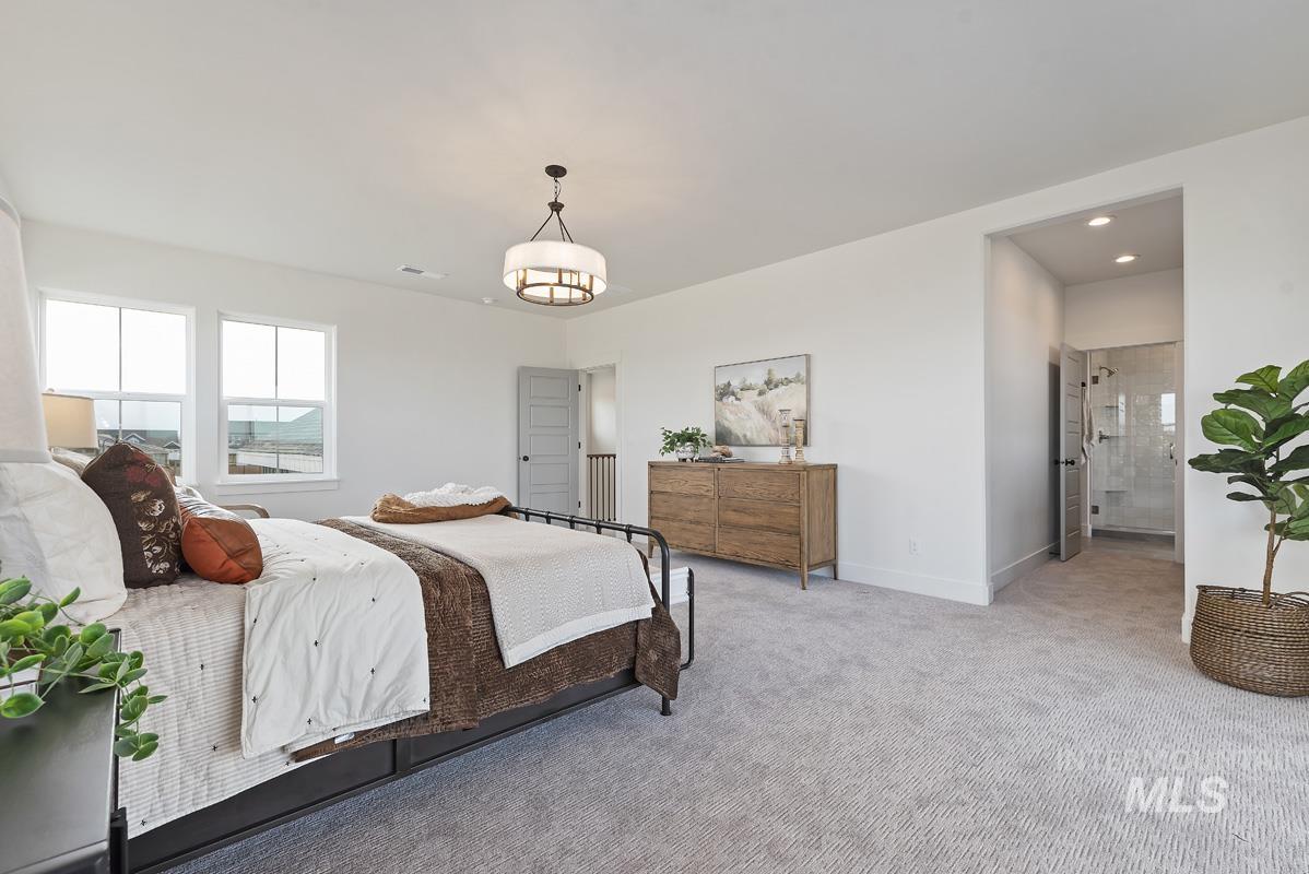 Carpeted bedroom with connected bathroom and recessed lighting