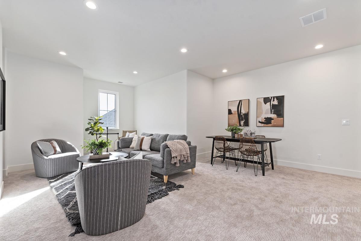 Living area with light carpet and recessed lighting