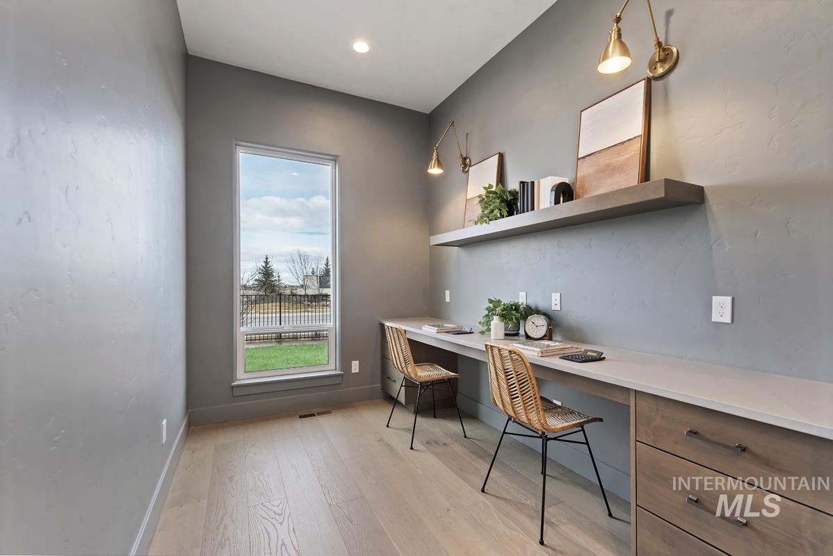 Office area with built in desk, light wood-style flooring, and recessed lighting