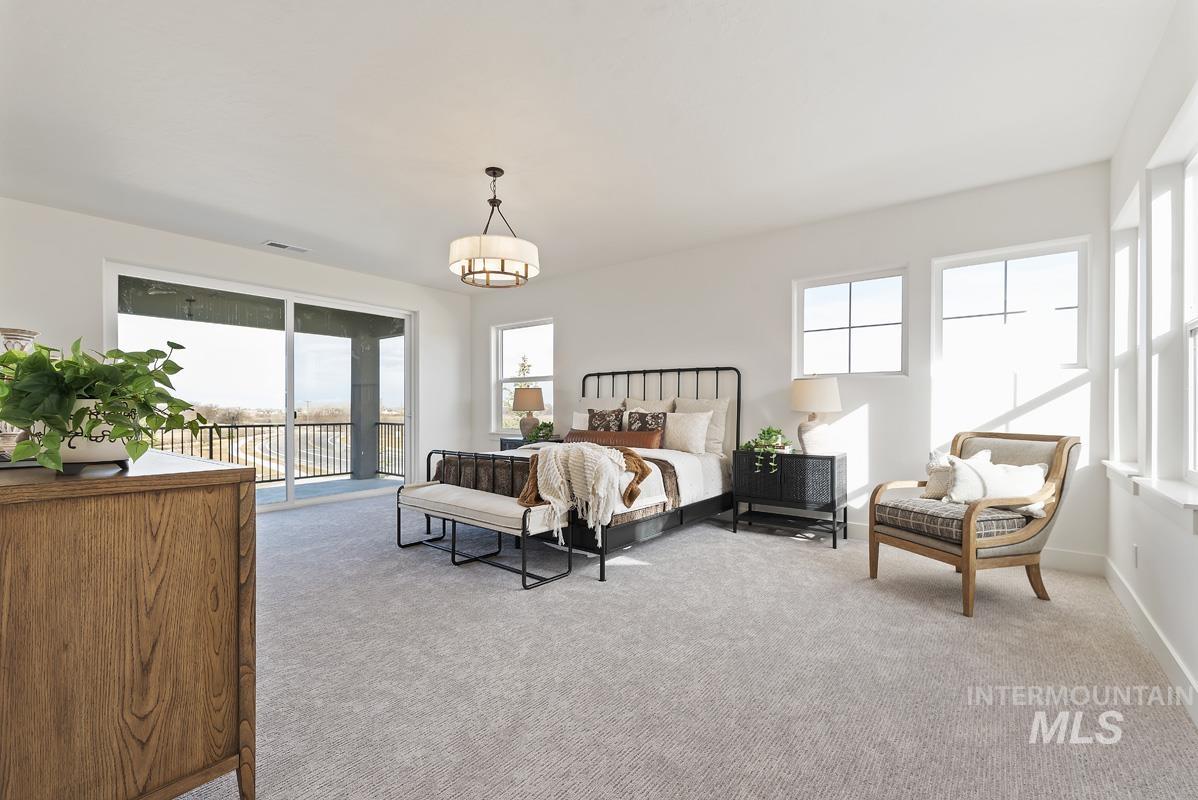 Bedroom featuring light carpet, multiple windows, and access to exterior