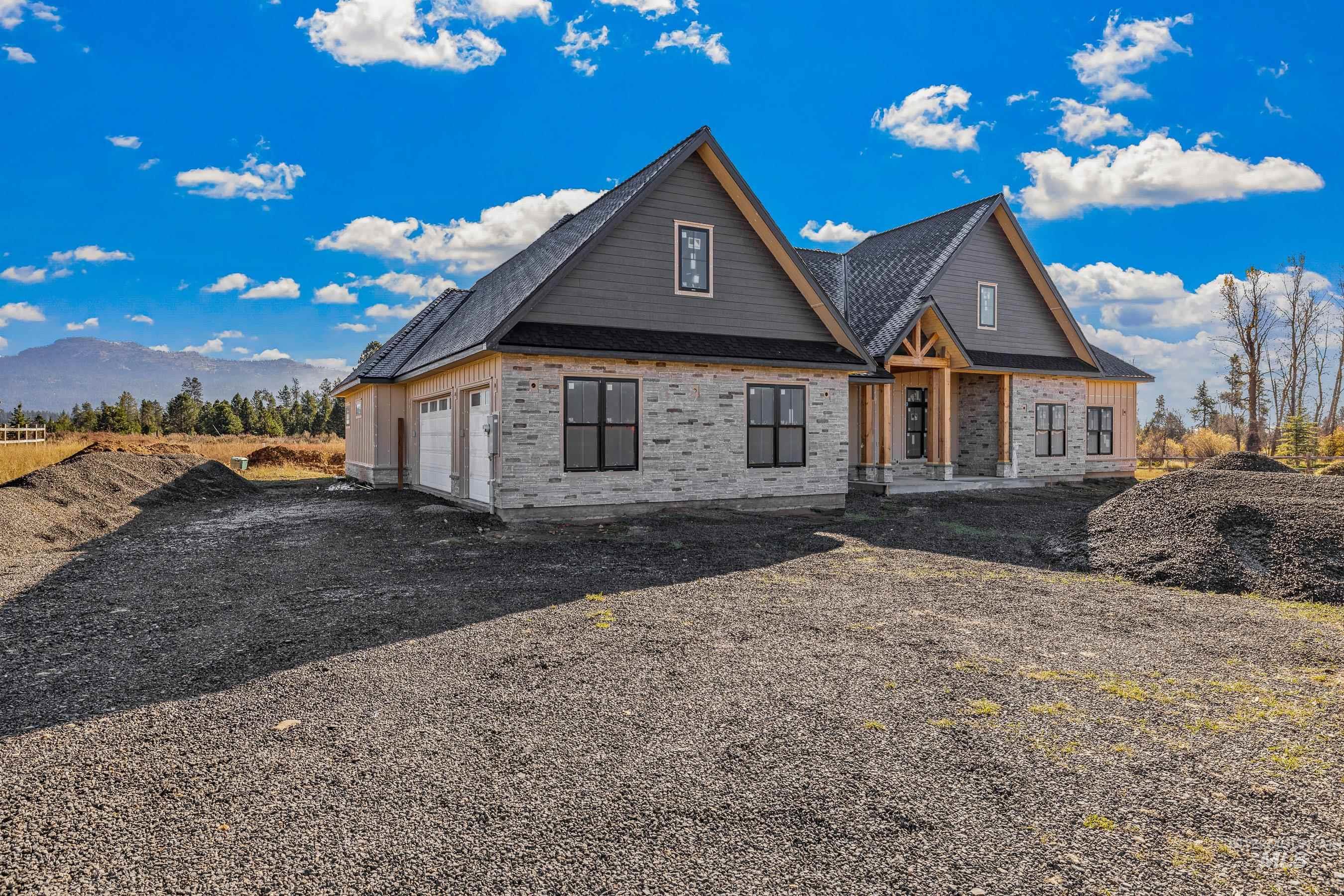 Property under construction with driveway, a shingled roof, and an attached garage