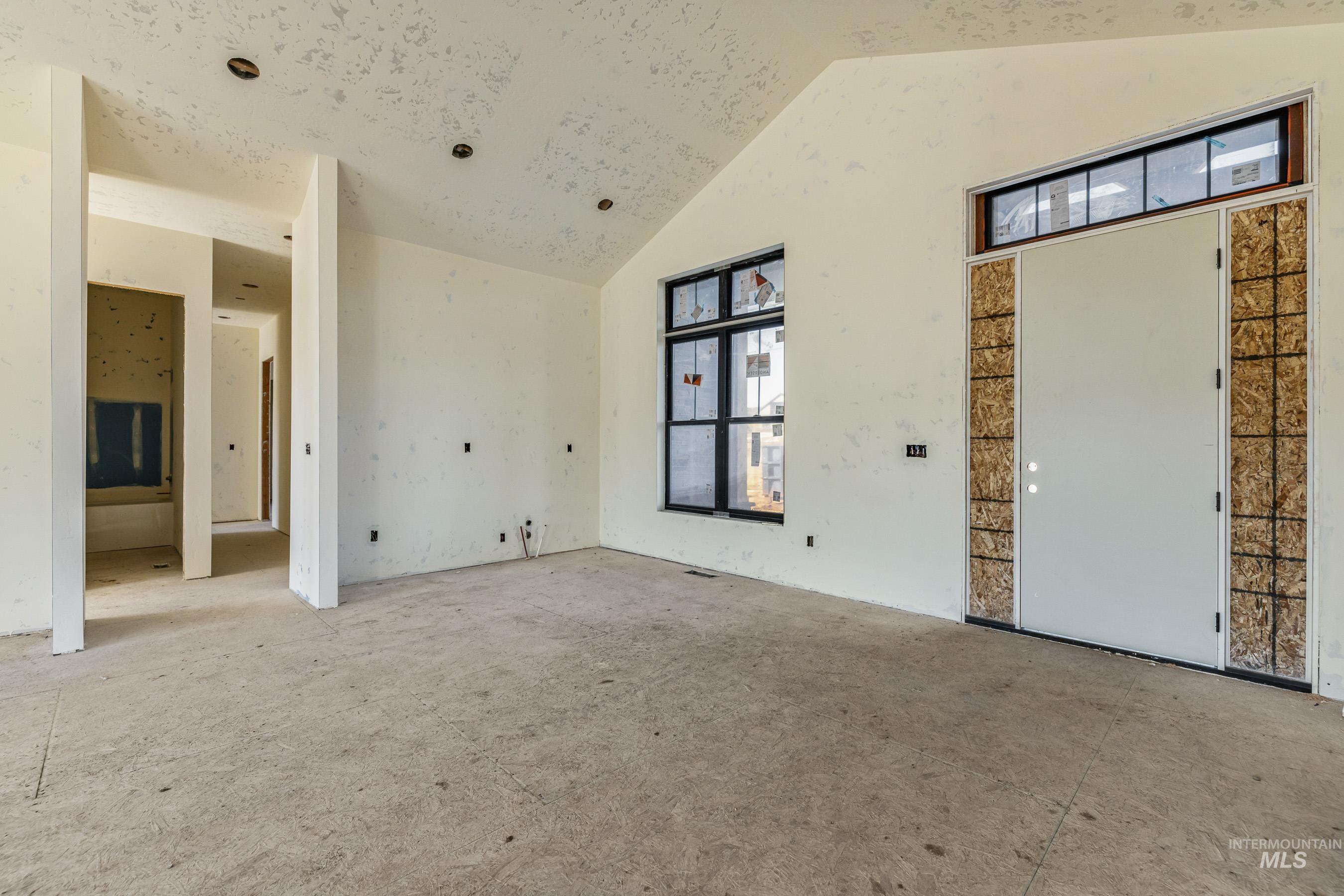 Spare room featuring high vaulted ceiling
