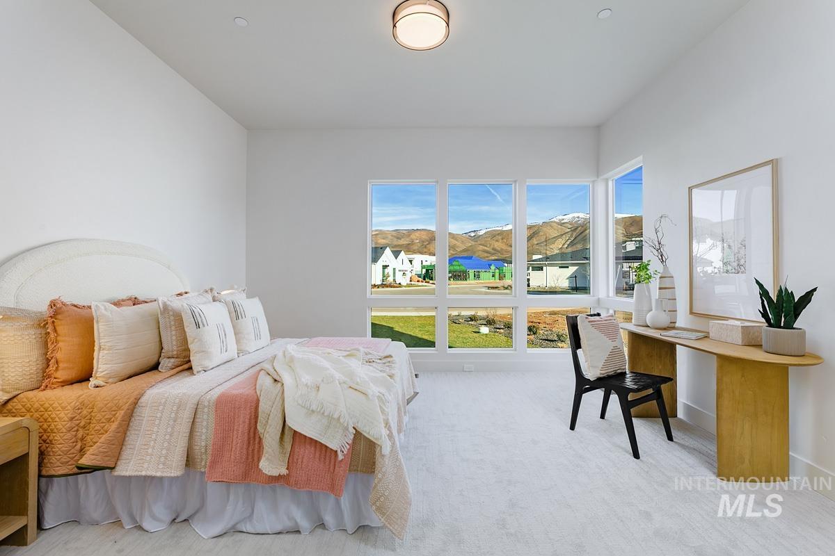 Bedroom with light carpet and a mountain view