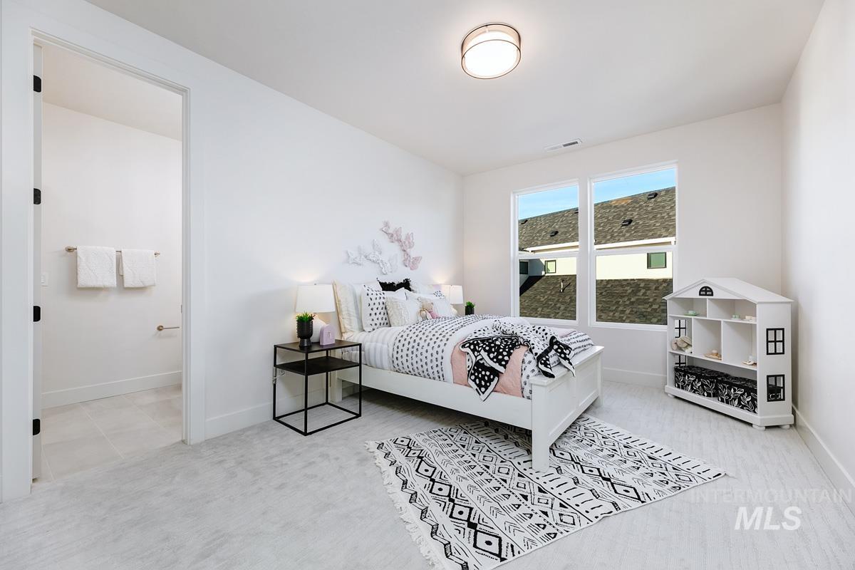 Bedroom featuring light carpet and connected bathroom