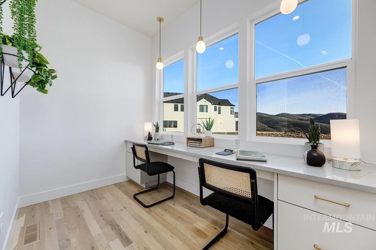 Office area with built in desk and light wood-type flooring