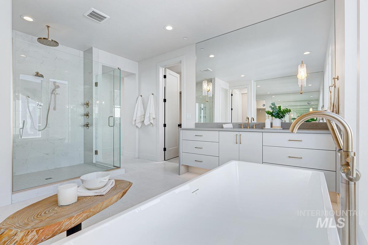 Full bathroom with a marble finish shower, vanity, recessed lighting, and a freestanding tub