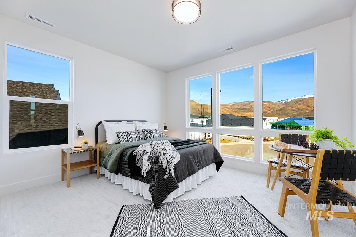 Carpeted bedroom with a mountain view and baseboards