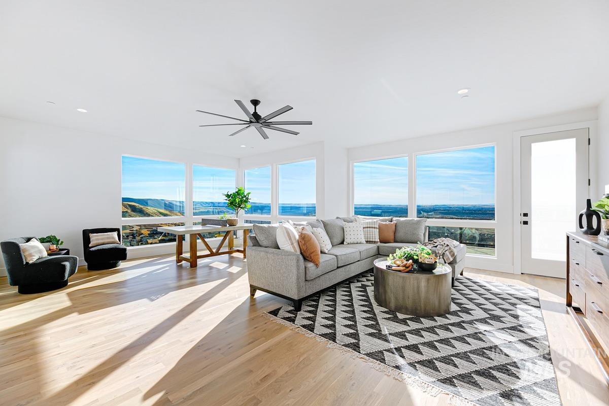Living area with light wood-style flooring, ceiling fan, and recessed lighting