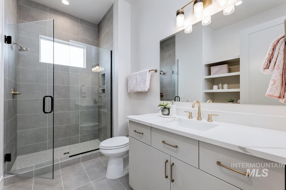 Full bath with vanity, light tile patterned floors, a stall shower, and recessed lighting