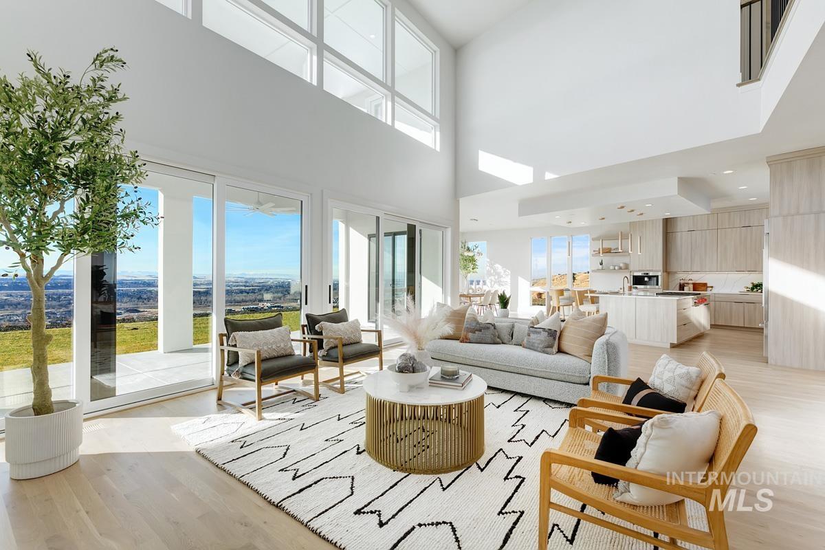 Living area with light wood-type flooring and a towering ceiling