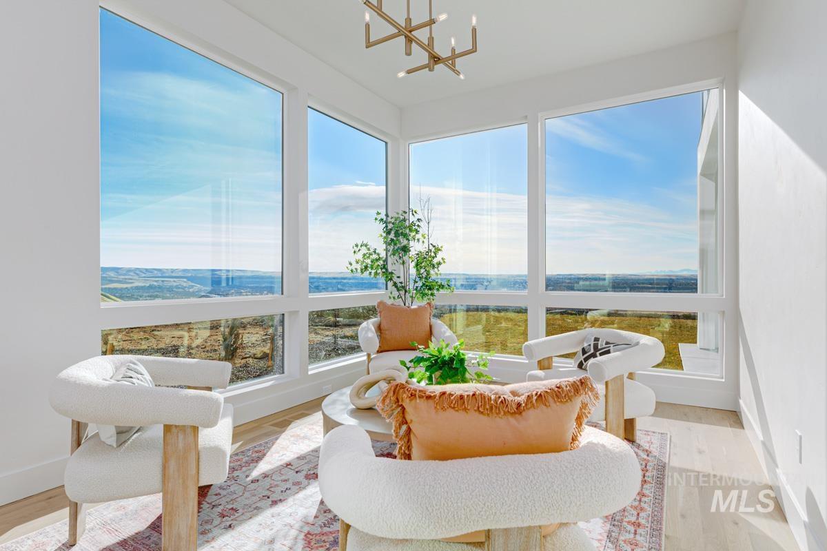 Sunroom / solarium featuring wood finished floors and a chandelier