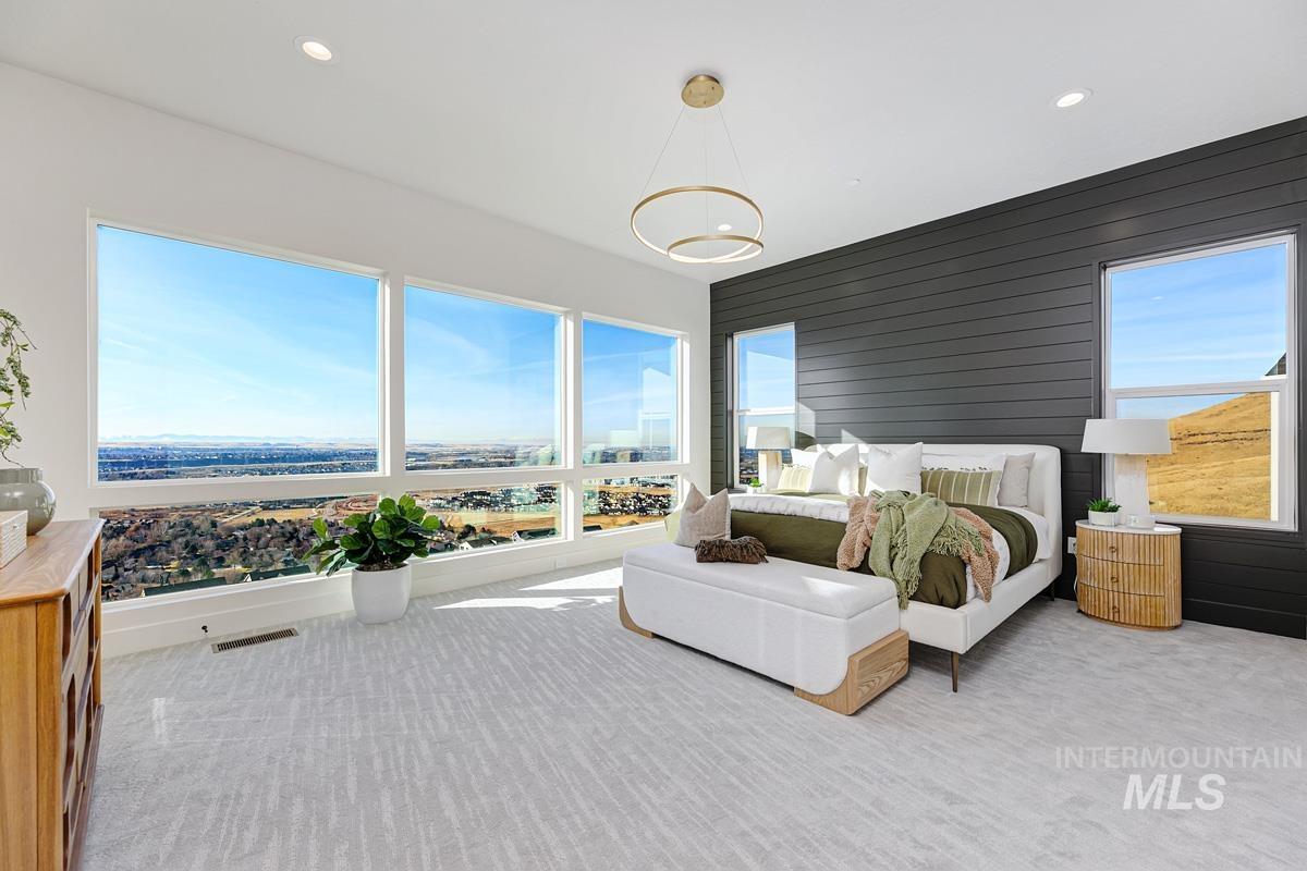 Bedroom with light colored carpet, recessed lighting, and wooden walls