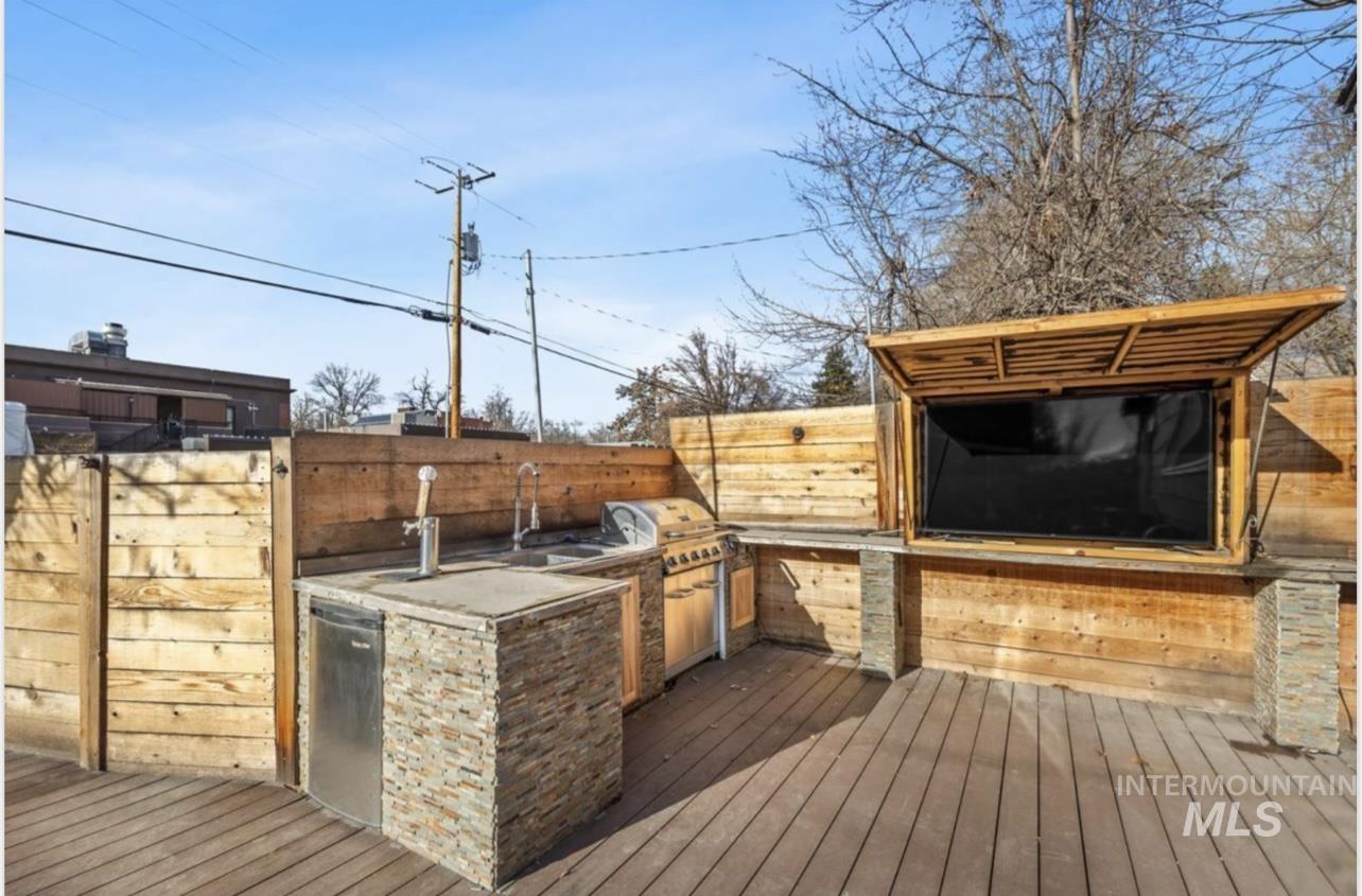Wooden deck with exterior kitchen and a sink