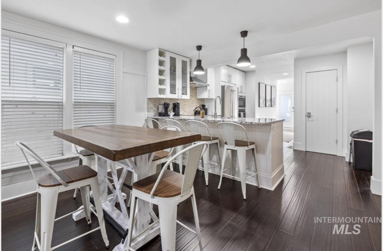 Dining space with dark wood-type flooring and recessed lighting