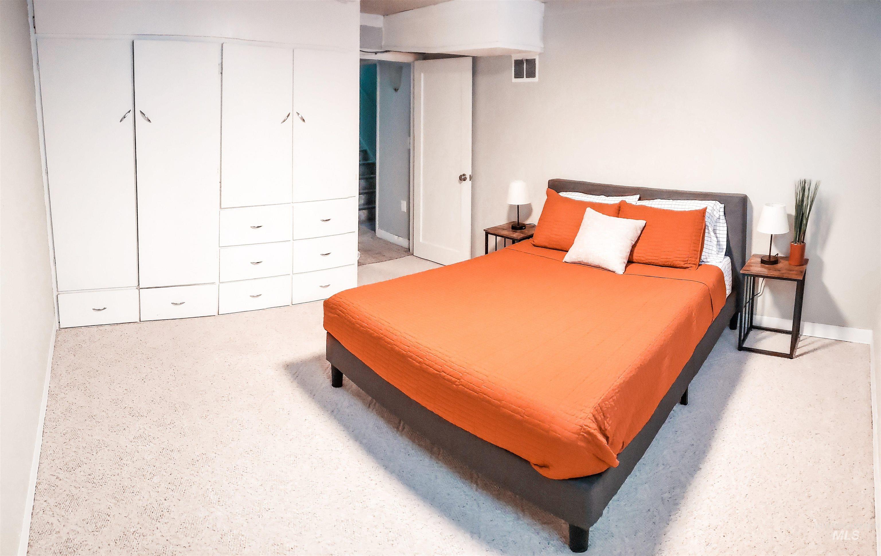 Bedroom featuring light-colored carpet flooring and neutral wall paint