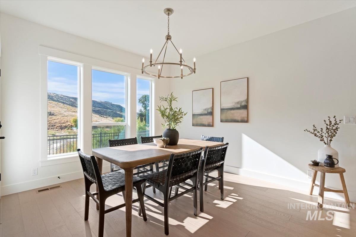 Dining space with a mountain view, light wood-type flooring, and a chandelier