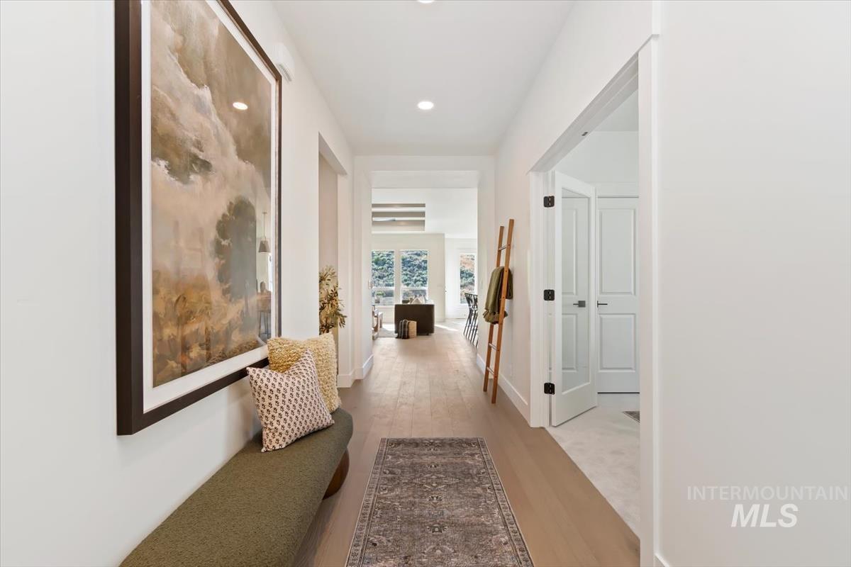 Hall with light wood-type flooring and recessed lighting