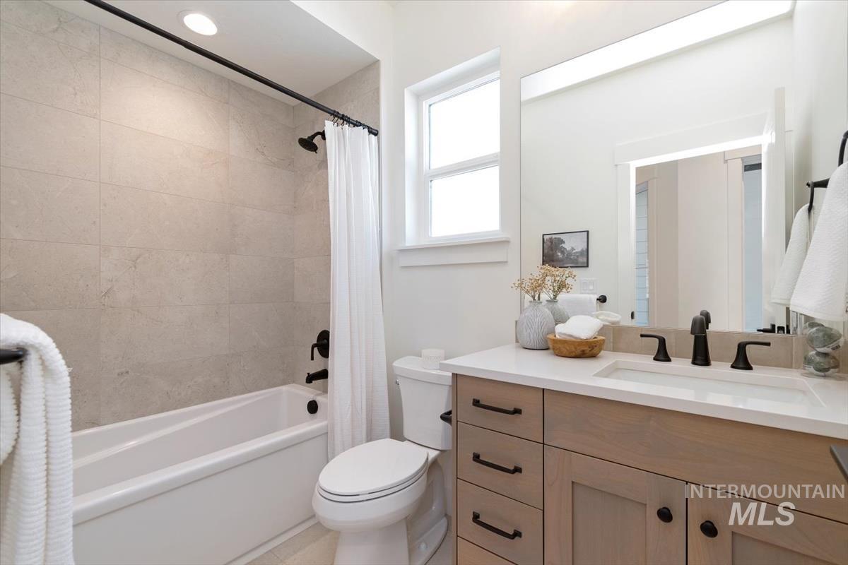 Full bathroom with shower / bath combo with shower curtain and vanity