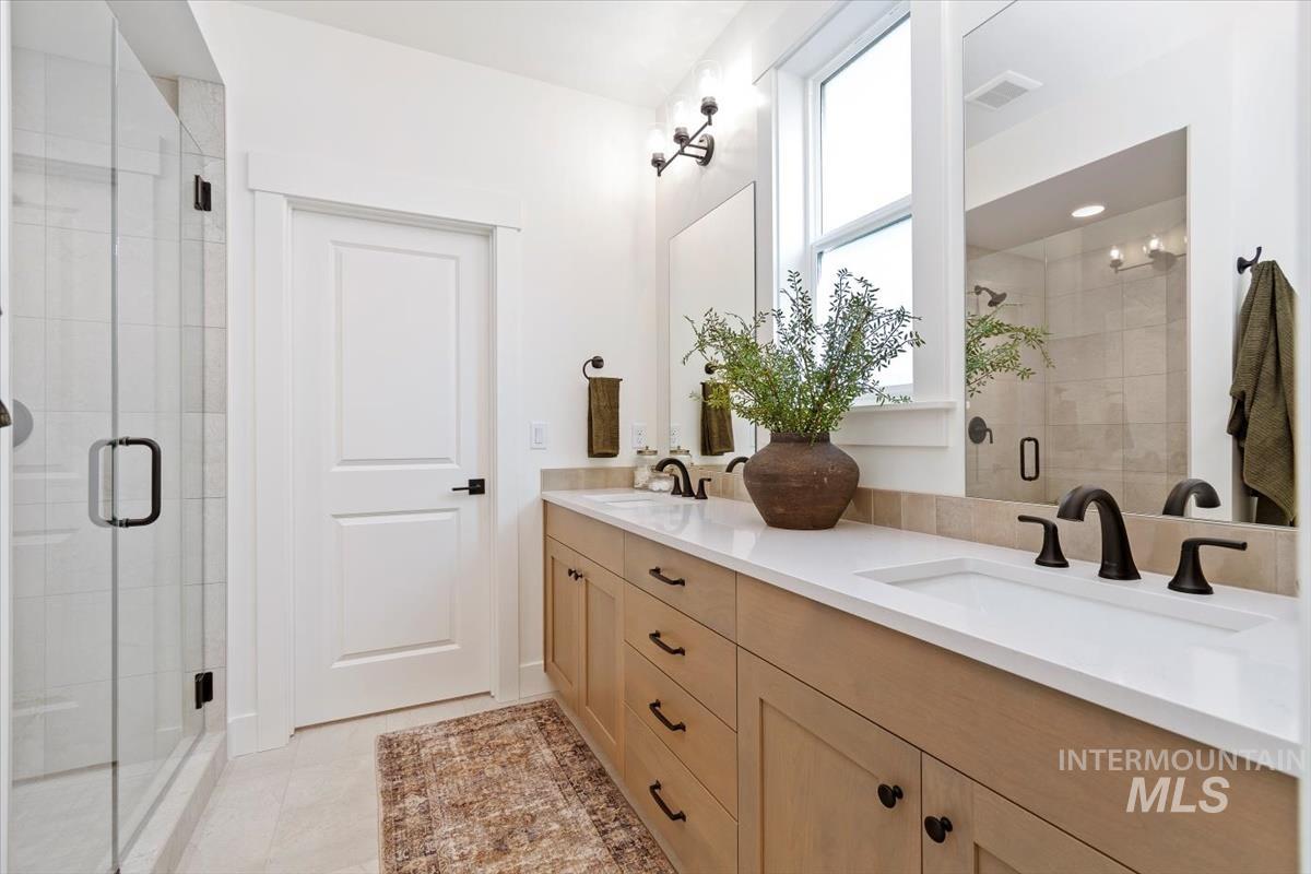 Bathroom with a shower stall and double vanity