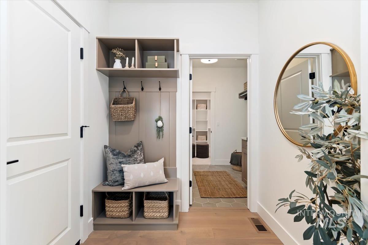 Mudroom featuring light wood-style flooring and baseboards