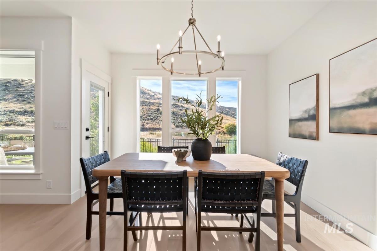 Dining space featuring light wood-type flooring, plenty of natural light, hanging lights, and a mountain view