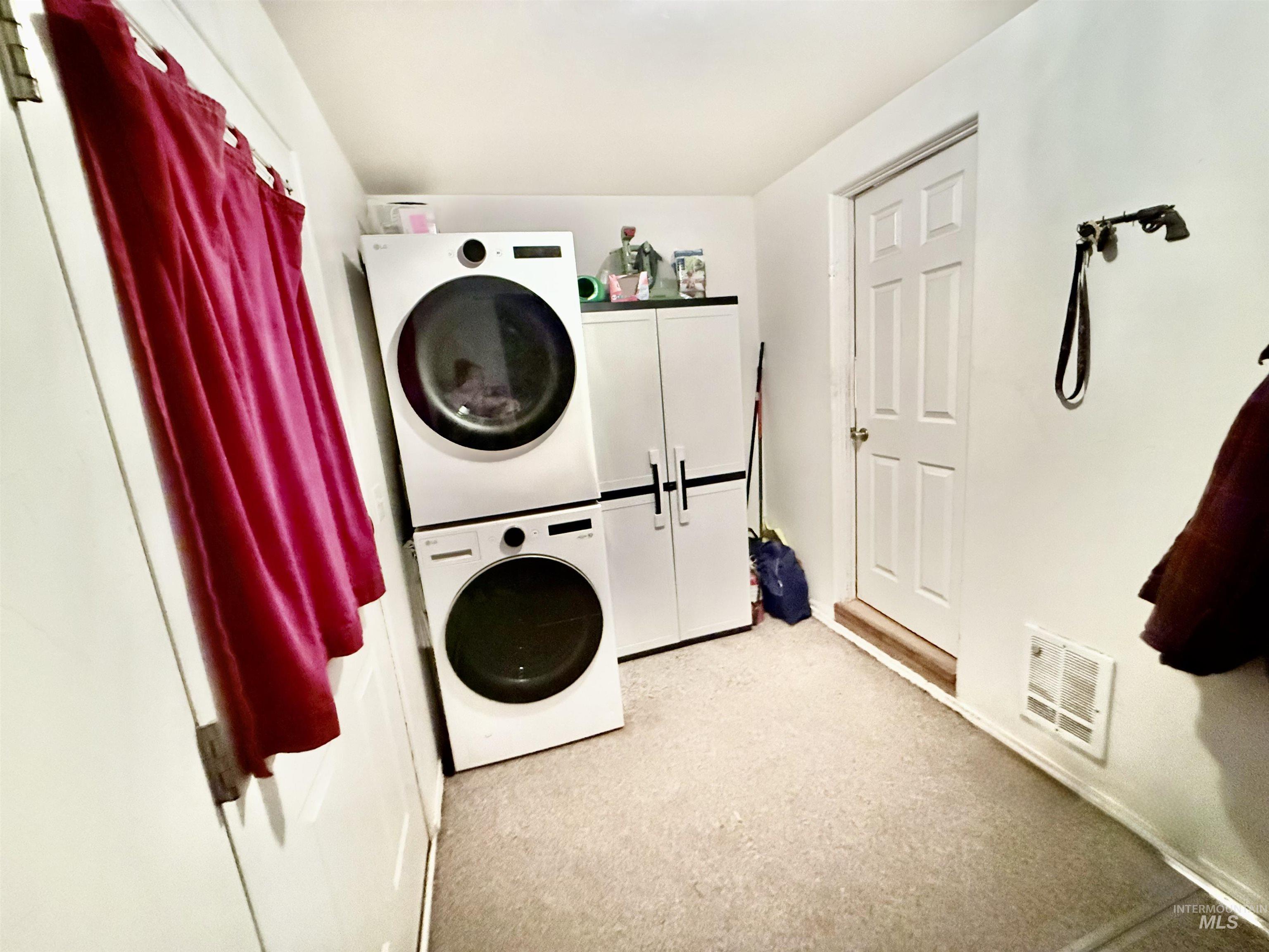 Laundry room featuring stacked washer / drying machine