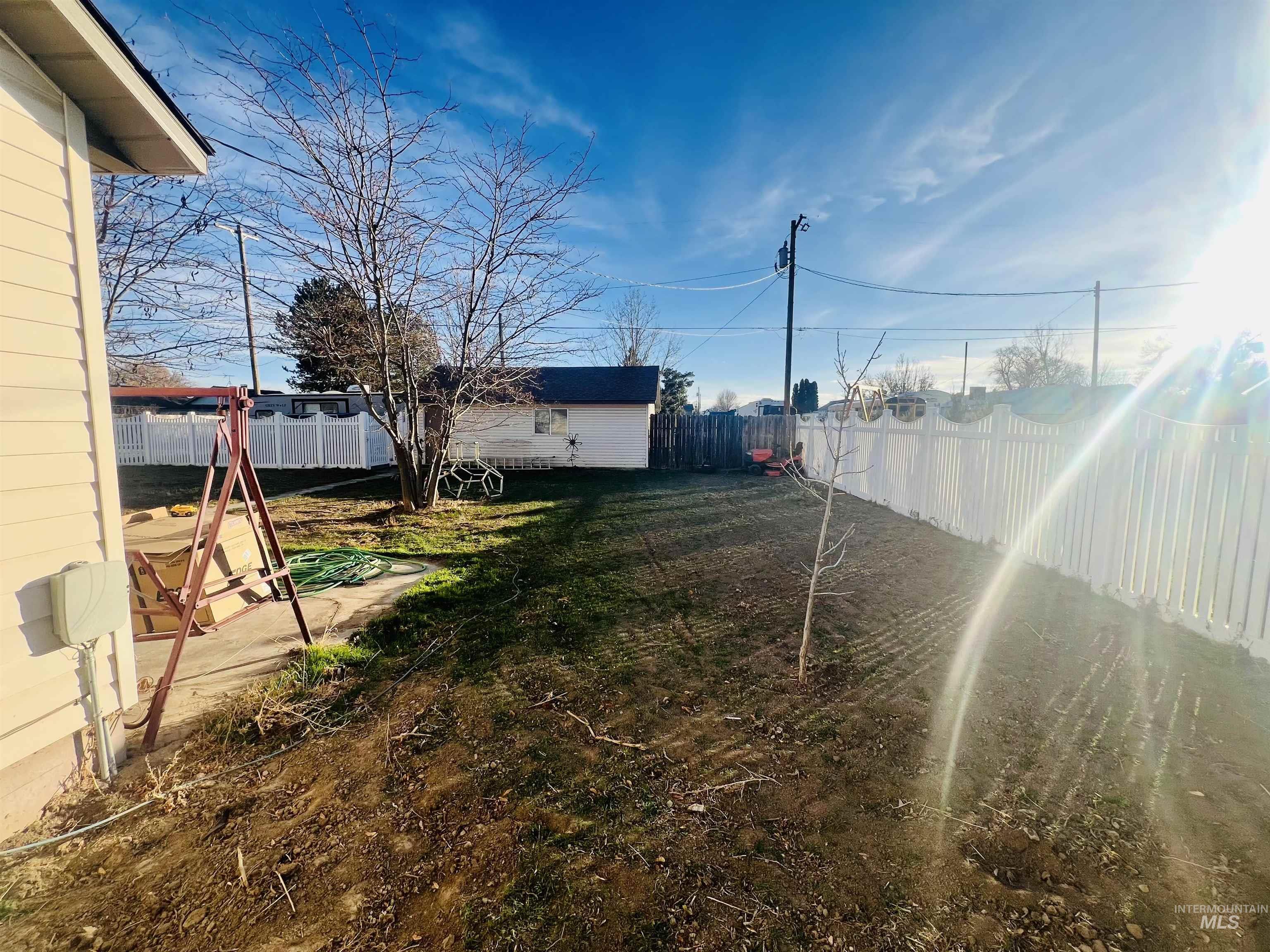 Fenced backyard with an outdoor structure and a patio