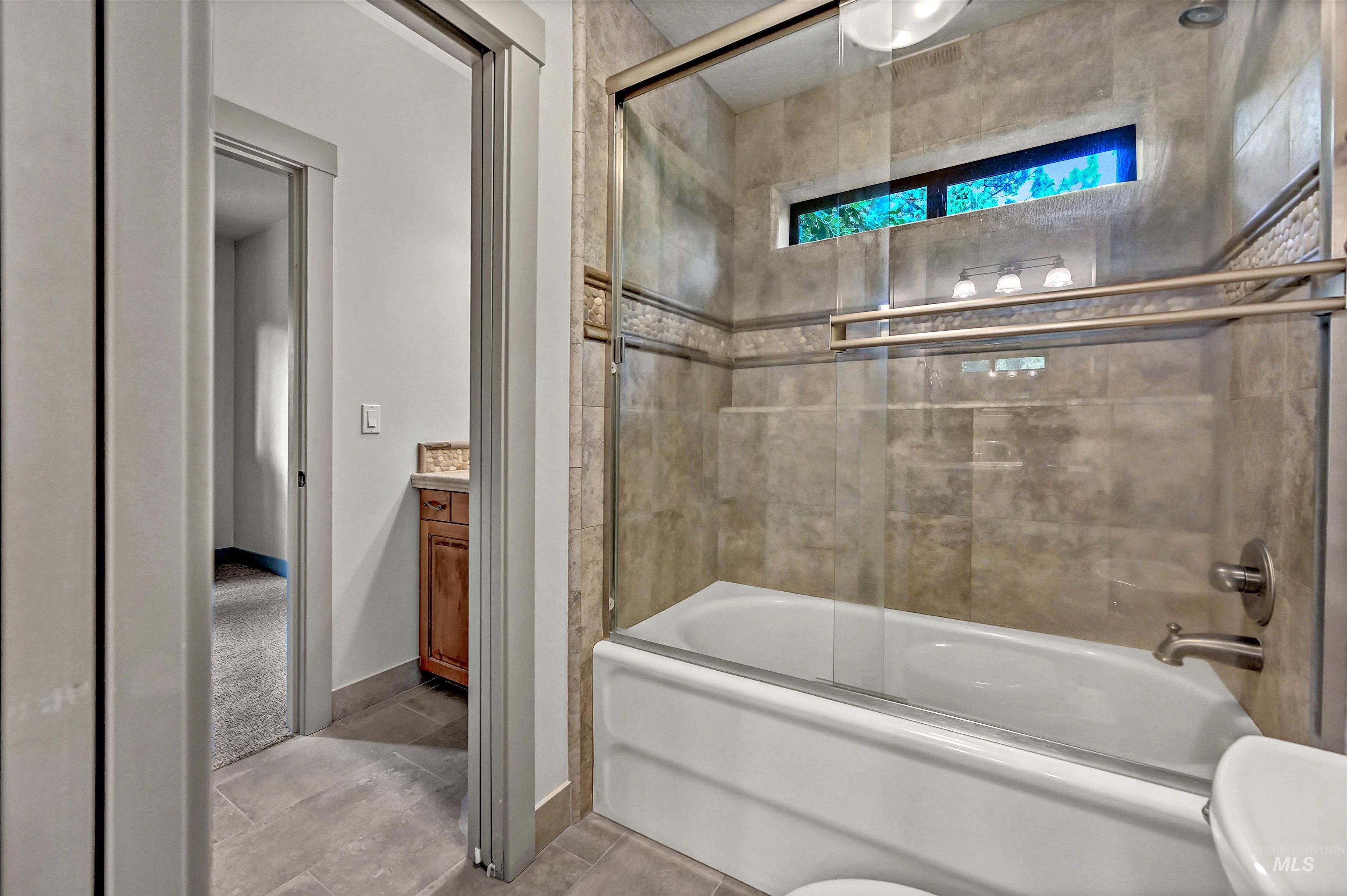 Bathroom featuring bath / shower combo with glass door and vanity