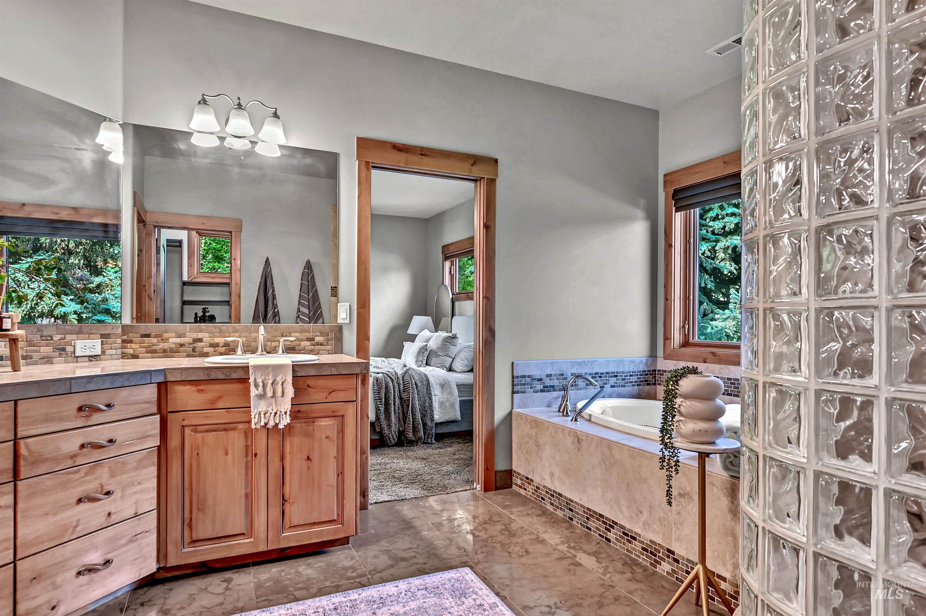 Ensuite bathroom featuring vanity and a bath