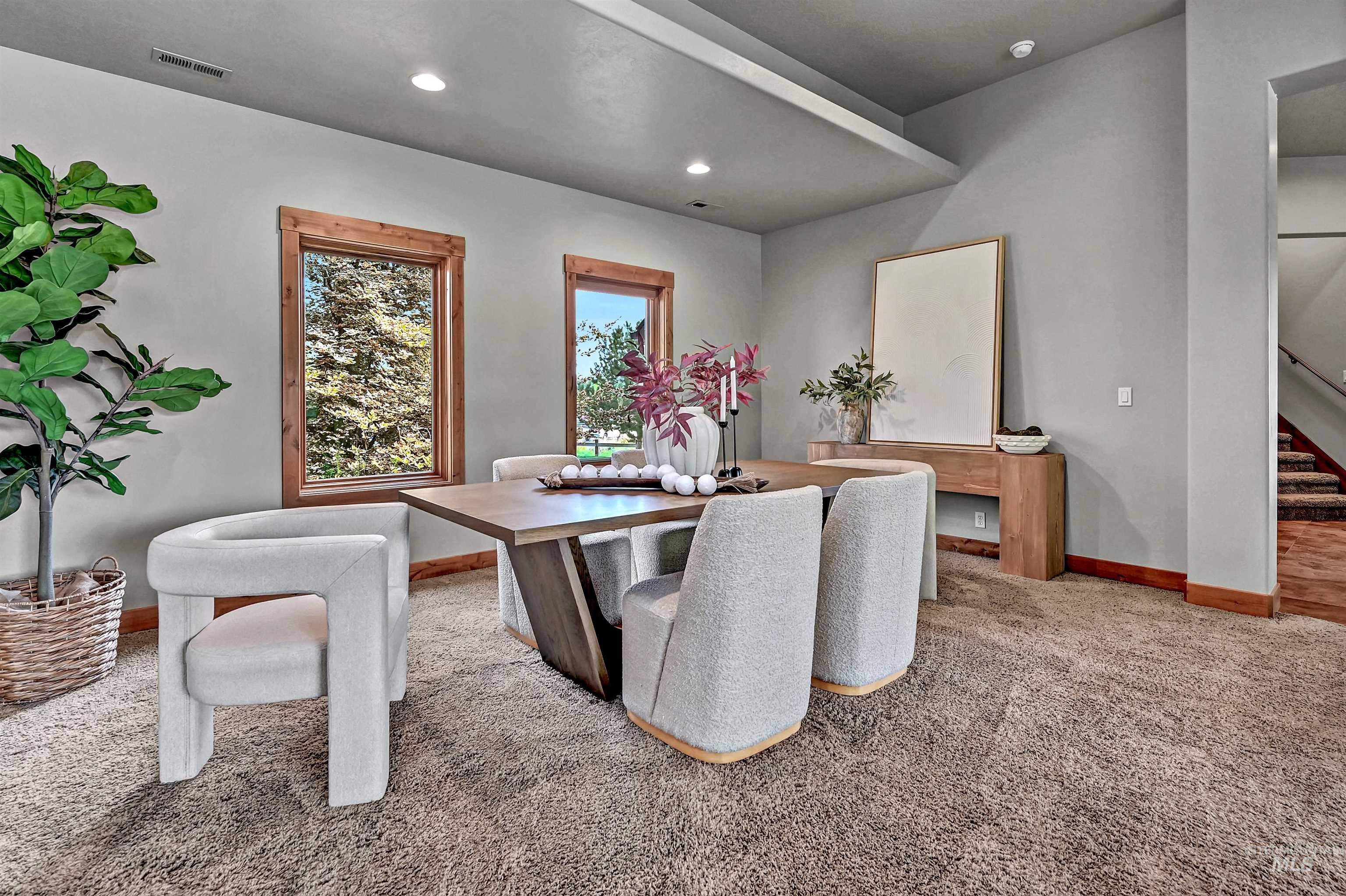 Dining space featuring light carpet, recessed lighting, and stairs