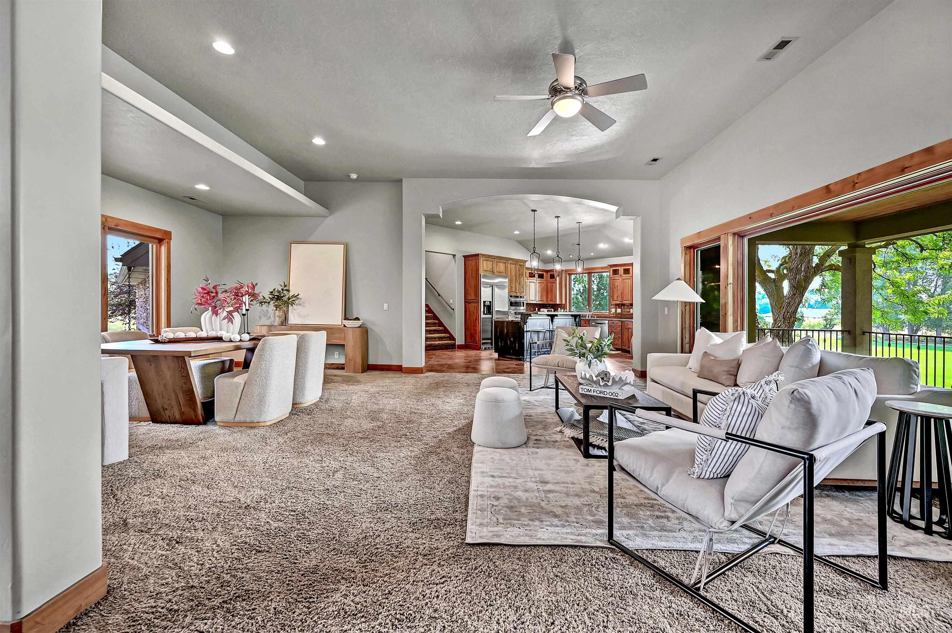 Living area featuring plenty of natural light, carpet floors, recessed lighting, a ceiling fan, and stairway