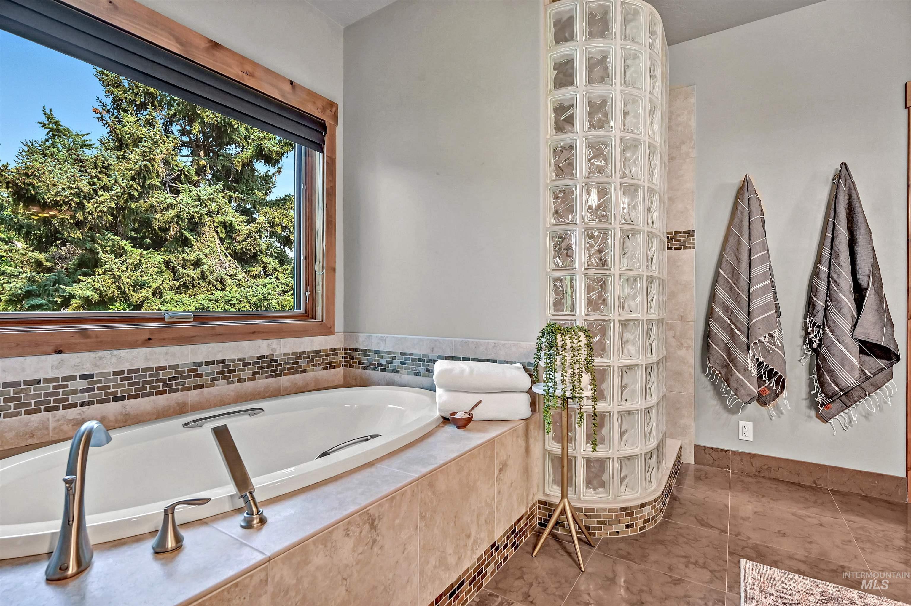 Bathroom with a walk in shower, a bath, and tile patterned floors