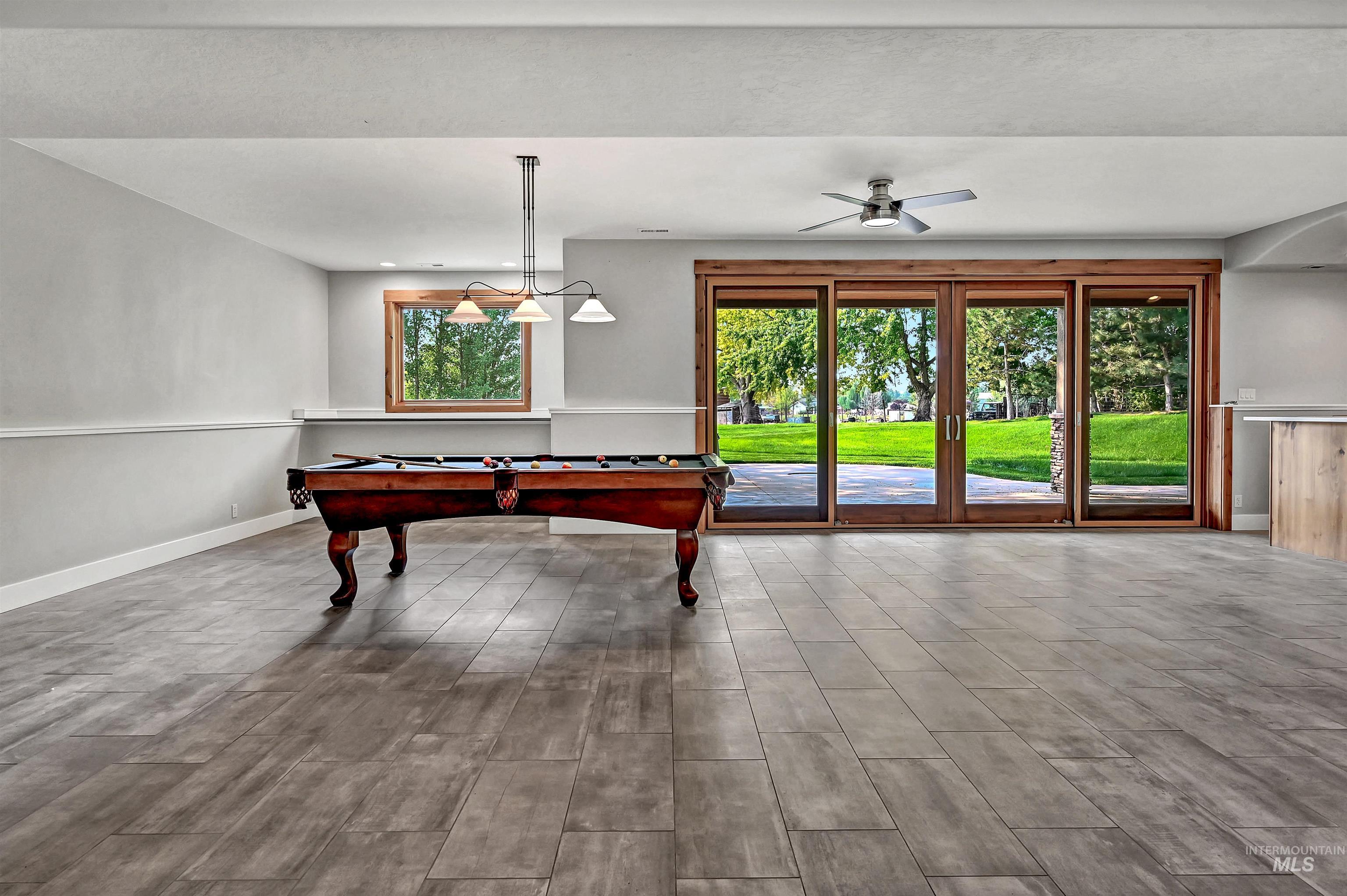 Rec room featuring wood finished floors, pool table, and ceiling fan