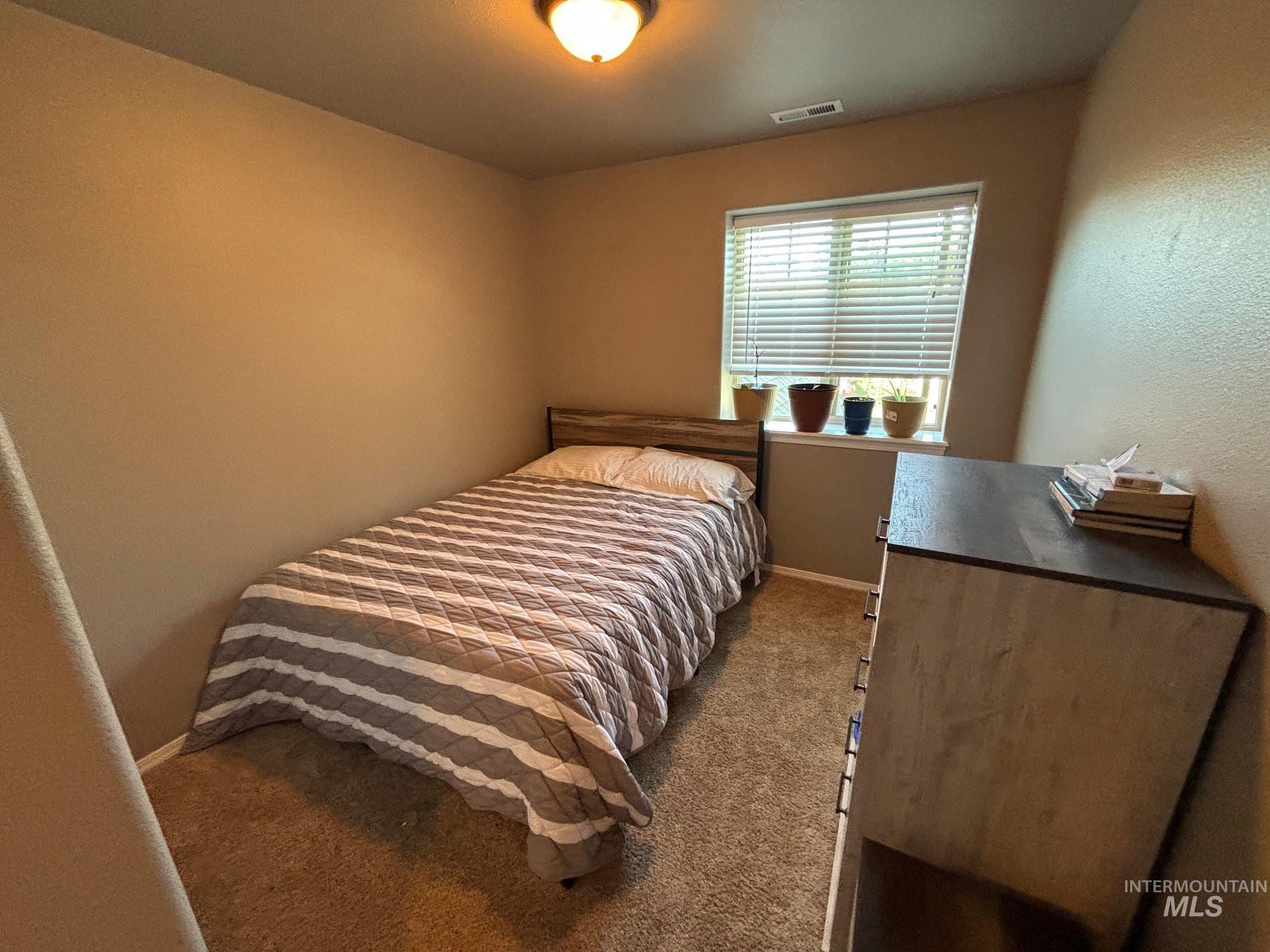 Bedroom with dark carpet and baseboards