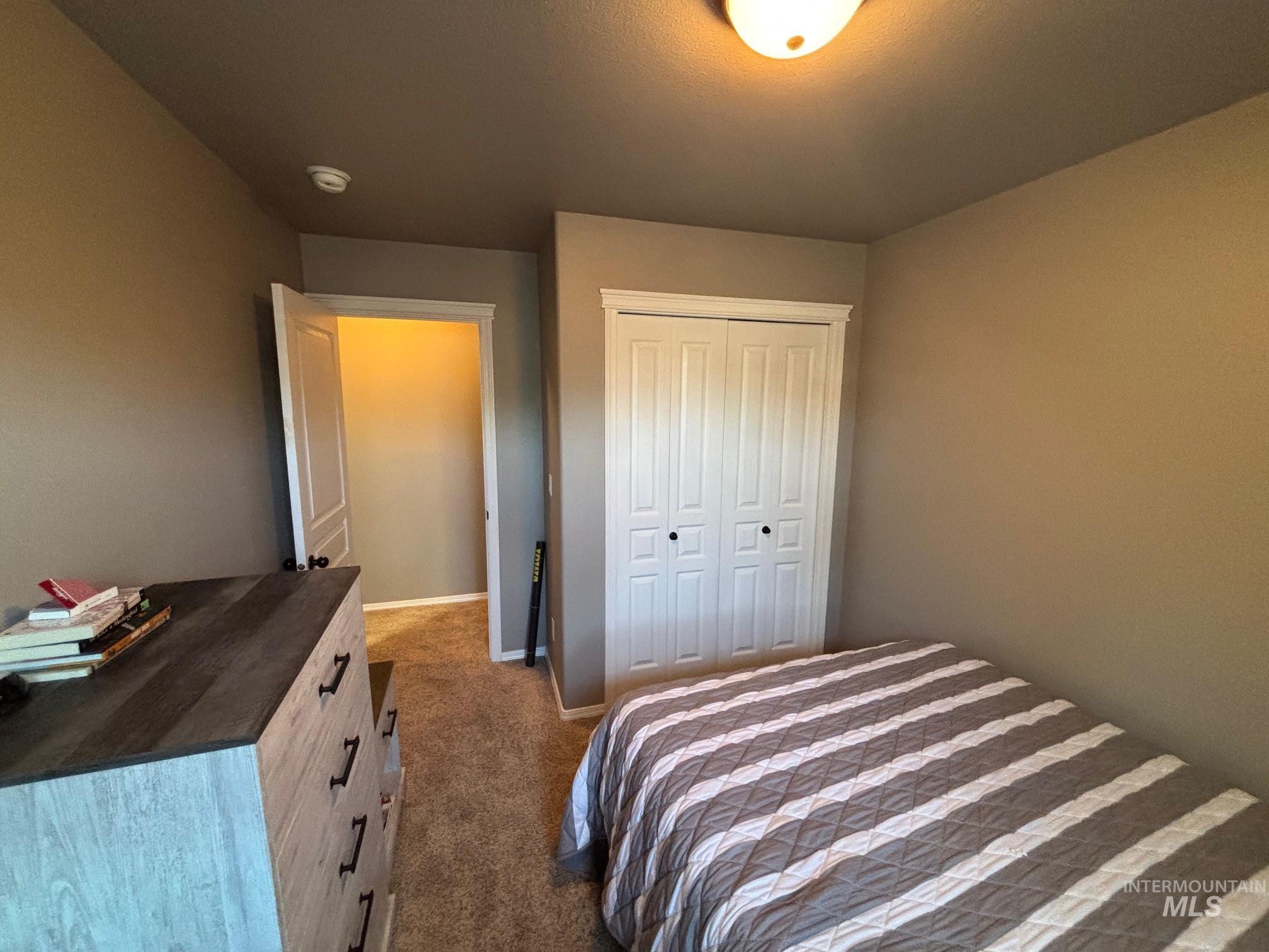 Bedroom with dark colored carpet and a closet