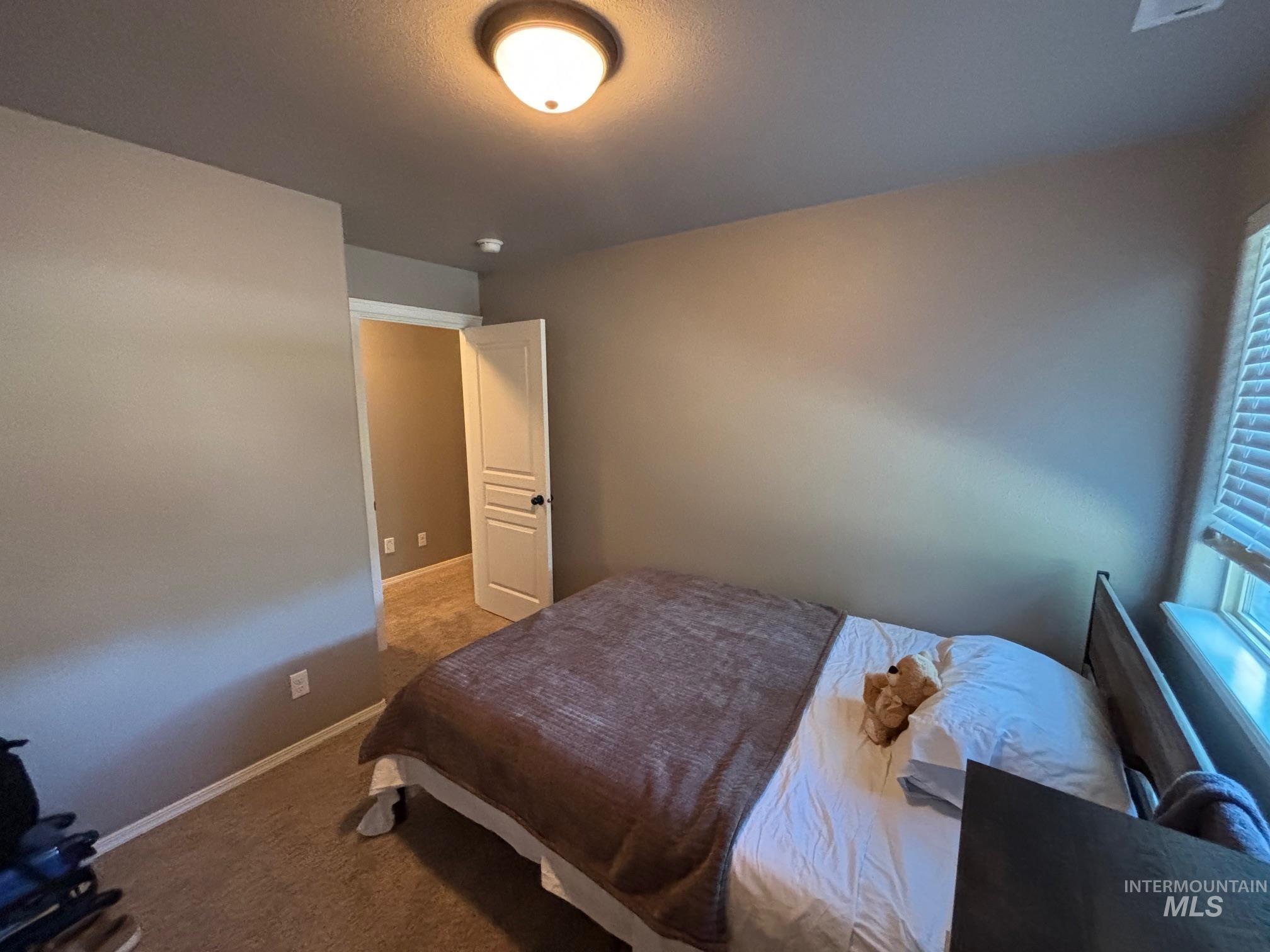 Bedroom featuring carpet and baseboards