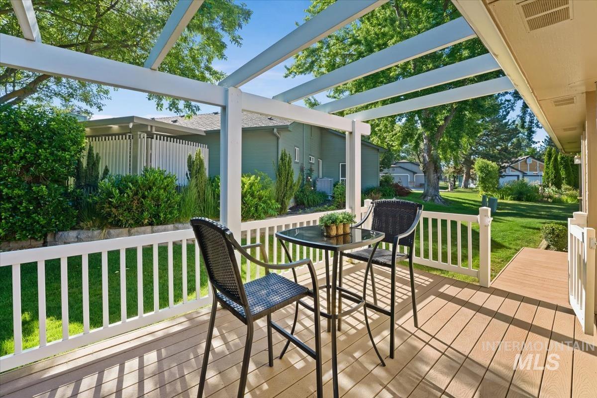 Covered outdoor patio featuring light composite decking, white pergola, and matching white railing