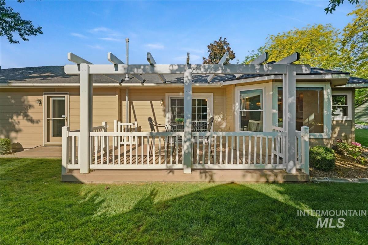 Exterior patio featuring a white pergola, composite decking, and white railing
