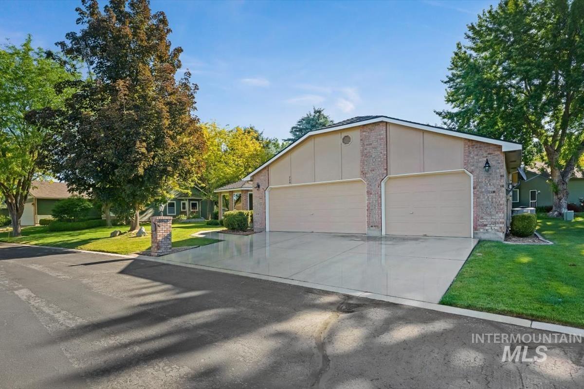 Two-car garage with tan doors and brick veneer siding