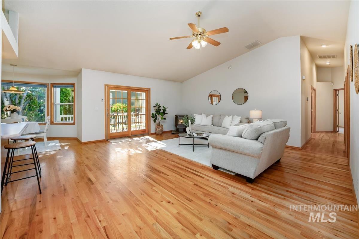 Spacious interior featuring wood-finish flooring, vaulted ceilings, and a ceiling fan