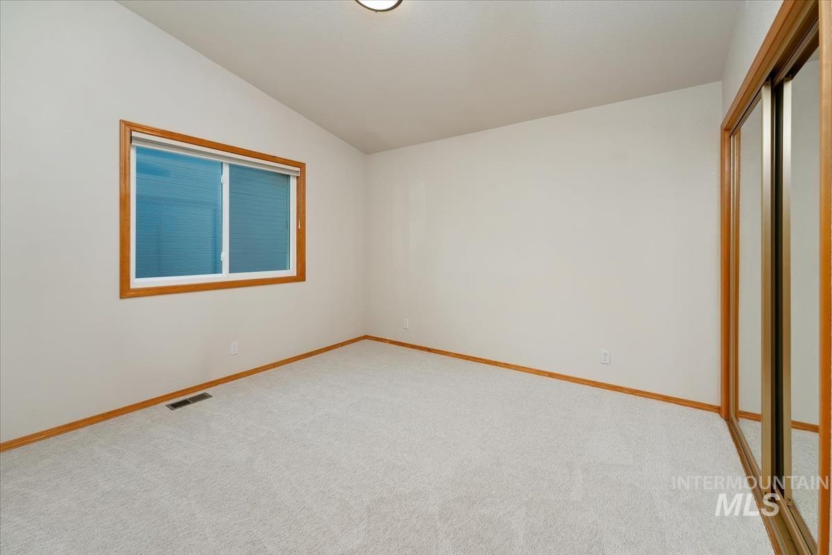 Neutral wall paint with wood-trim window and mirrored closet doors