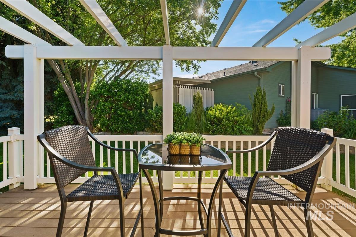 Exterior deck featuring a white pergola, wood-finish flooring, and white railing