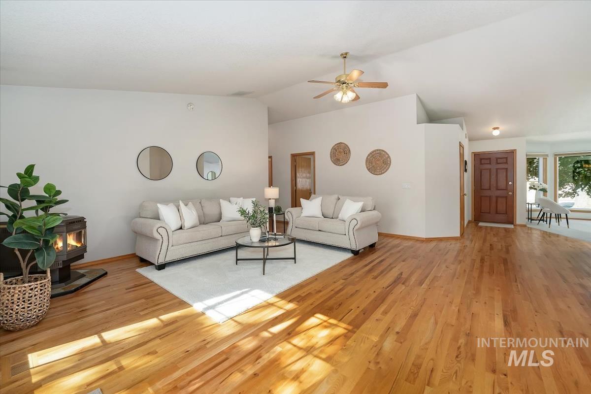 Expansive living space featuring wood-finish flooring and vaulted ceilings