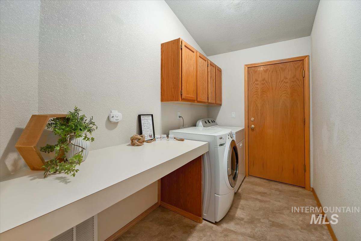 Laundry area featuring wood-finish cabinetry, an extended countertop, and a solid wood door