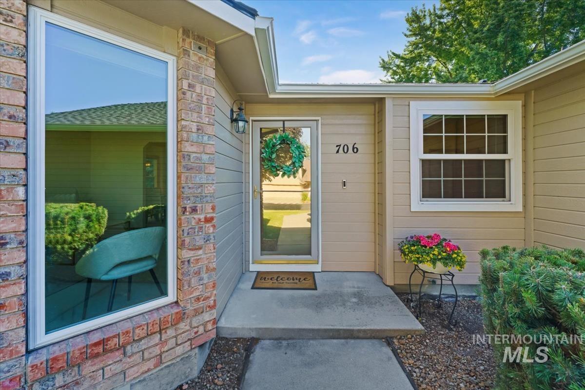 Welcoming entrance featuring a prominent brick facade and horizontal siding