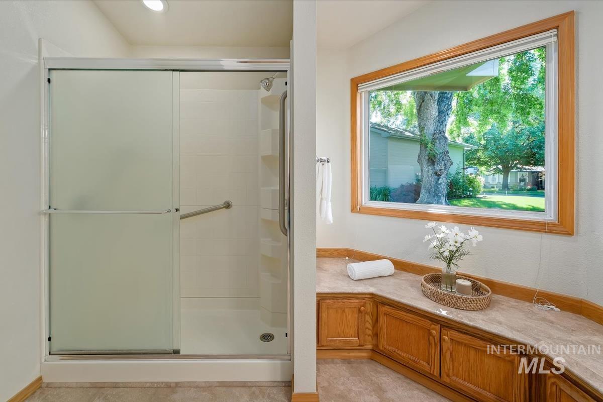 Sliding glass shower enclosure with grab bar and built-in shelving