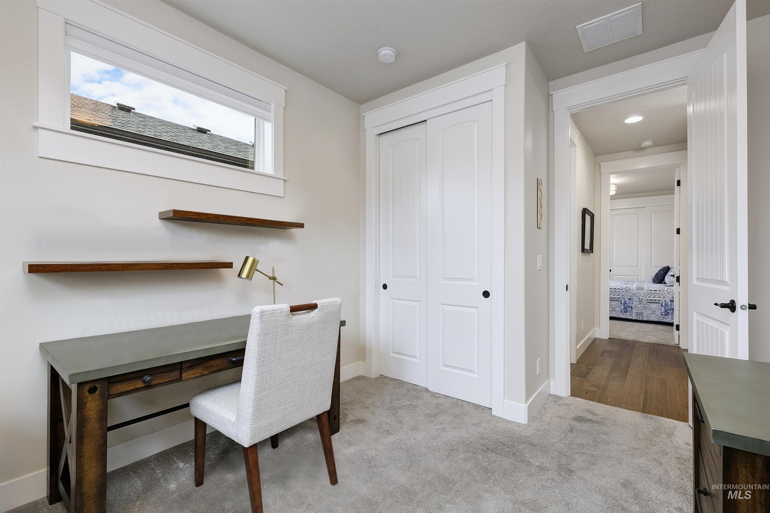 Office area with baseboards and light carpet