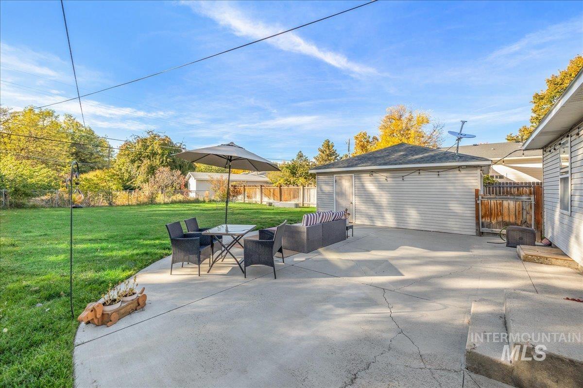 Fenced backyard featuring a patio area and an outdoor structure