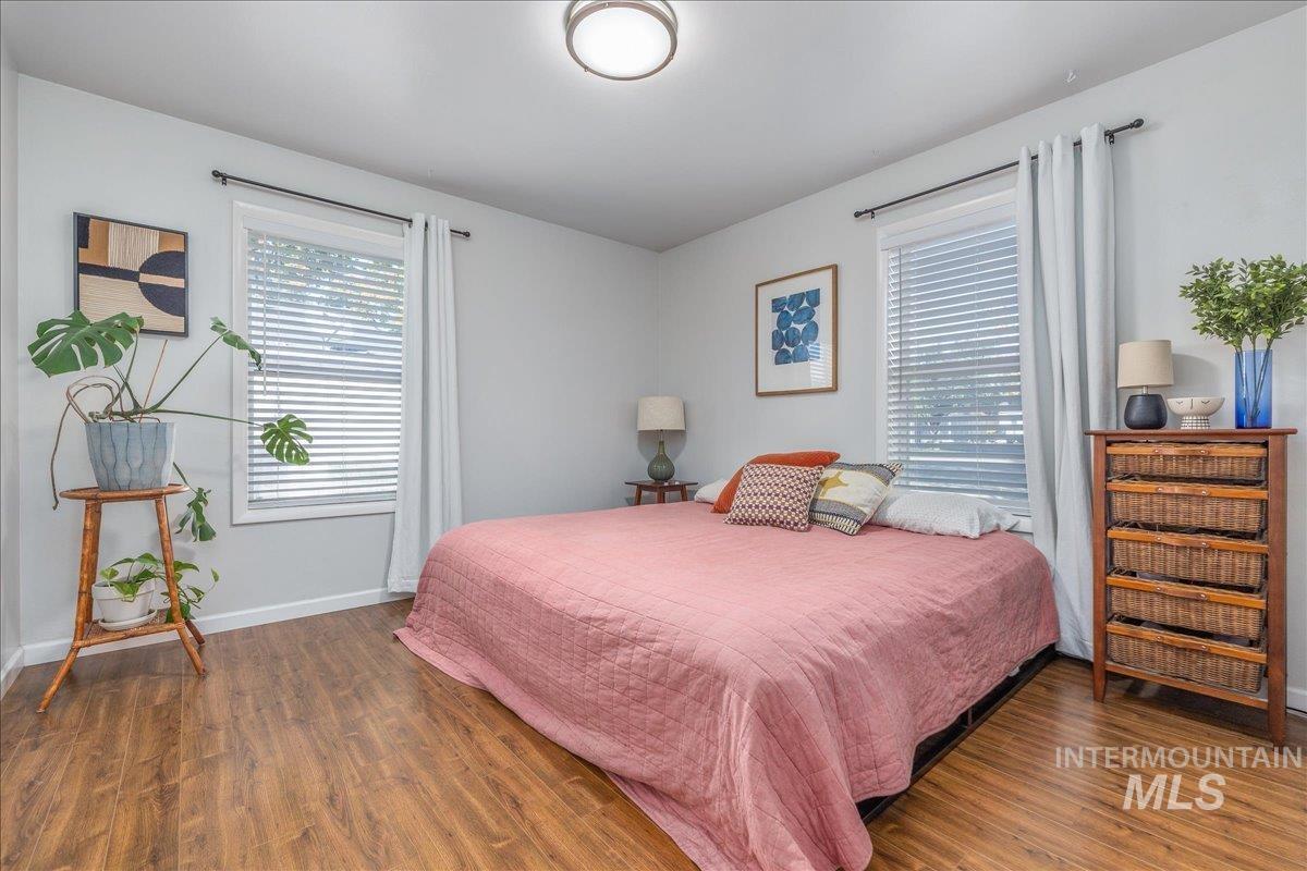Bedroom with wood finished floors and baseboards